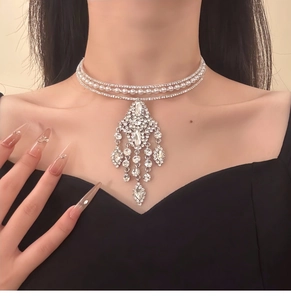 Detail of silver choker necklace with rhinestones, pearls and a fringe chandelier pendant