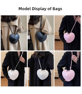 Dettaglio delle borse a tracolla a forma di cuore in pelle nera, bianca e rosa moda
