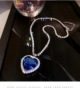 Makro-Detail einer herzförmigen blauen Edelsteinkette mit funkelnden Diamanten rundum