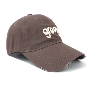 Detailed view of the distressed brim and 3D groovy embroidery on this vintage brown cap