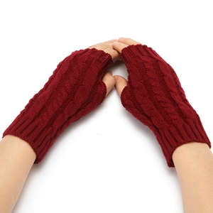 Close-up of dark red cable knit fingerless gloves showing detailed winter wool texture