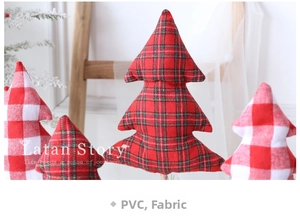 Close-up of red plaid fabric Christmas tree ornaments on a wooden stand in a home setting