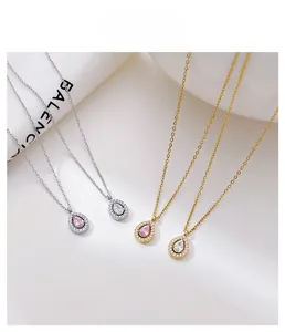 Detailed view of teardrop zircon pendants in gold and silver finishes with crystal halo