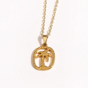 Detail shot of golden coconut tree pendant necklace with hollowed oval frame and matte finish