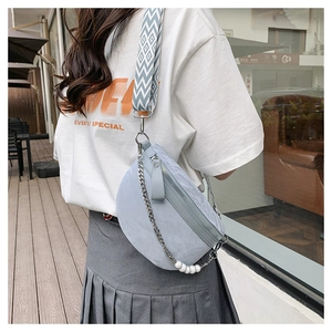 Close-up of light blue marble textured moon bag with pearl chain and woven strap