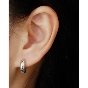 Close-up of minimalist S925 sterling silver hoop earring on ear showing polished finish