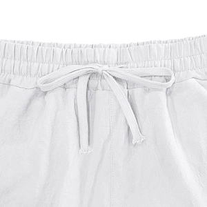 Detail of white linen pants featuring elastic waistband with adjustable drawstring