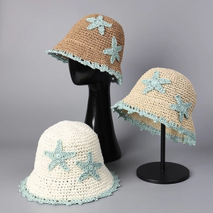 Detail of handmade straw hats with starfish accents and scalloped edges for beach vacations