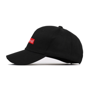 Detail of red rectangular patch with white embroidery on a black cotton baseball cap