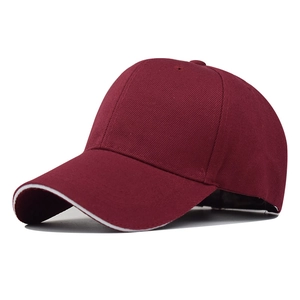 Detail view of maroon baseball cap featuring a distinctive white sandwich brim design