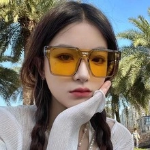 Close-up of square sunglasses with yellow transparent lenses and FEND logo on the bridge