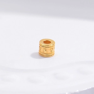 Detailed view of S925 silver gold-plated mantra barrel bead with 3D embossed texture