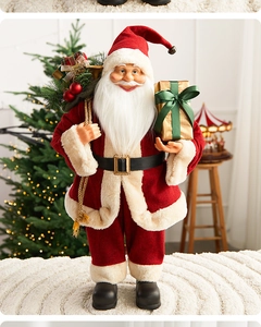 Detailed view of Santa Claus doll with red robe and gold gift box in a warm holiday setting