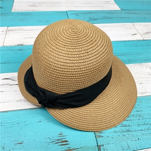 Dettaglio del cappello di paglia a trama fitta con nastro decorativo in tessuto nero