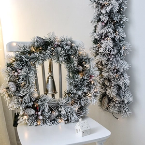 Luxurious flocked Christmas wreath with pine cones, red berries and warm LED lights