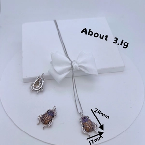 Detailed view of beetle pendant necklace with zircon inlays and dimensions 24mm x 17mm