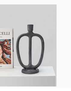 Macro detail of modern matte black candlestick with textured surface and sleek oval design