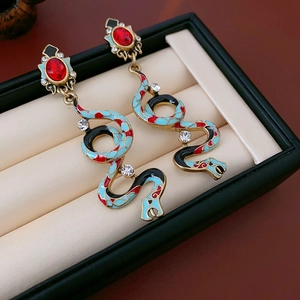 Detailed close-up of snake-shaped earrings with colorful enamel and crystal inlays