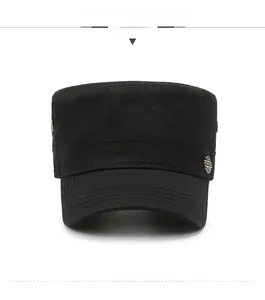 Detail view of black canvas cadet cap with metallic shield emblem and reinforced stitching