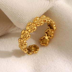 Close-up of a 18K gold-plated stainless steel flower ring on white knitted fabric