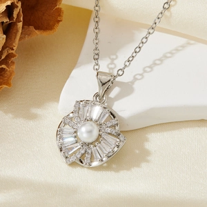 Vue macro du pendentif soleil argenté avec perle et zircon sur fond en soie soyeuse