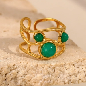 Macro view of gold plated open ring featuring three tiered green round stones