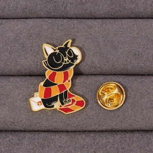 Cute black cat enamel pin with orange scarf sitting on a letter, gold metal brooch