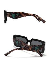 Detail of square oversized sunglasses with tortoiseshell temples and green triangle decor