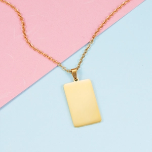 Macro detail of a mirror-polished gold rectangular pendant on a slim metal necklace chain