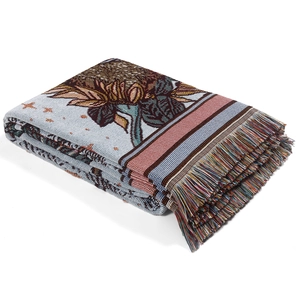 Macro detail of Bohemian woven blanket showing sunflower patterns and colorful tassels