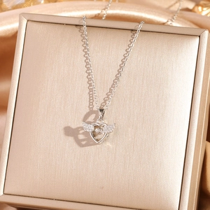 Silver angel wing heart necklace with sparkling crystals on premium silk background