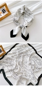 Detailed view of black and white graffiti print silk scarf with elegant drape and texture