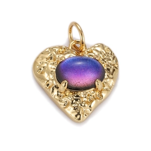 Macro detail of golden heart pendant featuring a blue-purple gradient oval gemstone