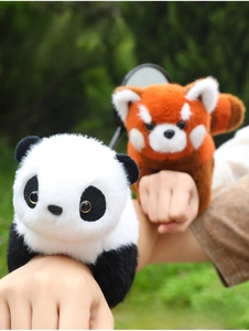 Detail shot of plush panda and red panda snap bracelets worn on a child's wrist