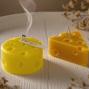 Detail of yellow cheese-shaped candles with realistic textures and a Thank You tag