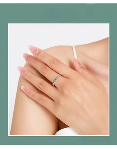 Macro shot of silver minimalist fish ring with geometric texture on a female hand