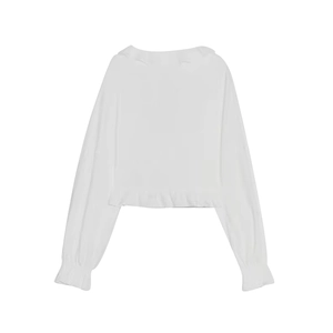Detailed view of white blouse featuring ruffled hem and elasticated cuff sleeves