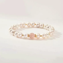 Macro detail of natural freshwater pearl bracelet with pink gemstone and gold spacers