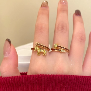 Detail of gold-plated horse charm ring with red enamel inlay and crystal accents