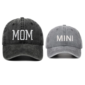 Detail of embroidered MOM and MINI text on washed denim baseball caps for families