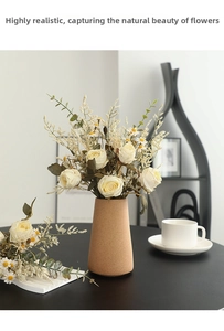 Detail of faux cream roses and white daisies in a textured vase for home decor