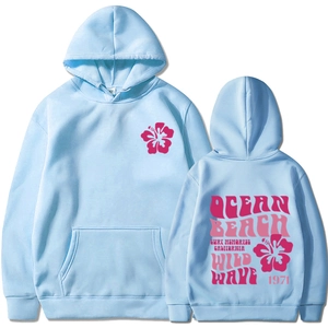 Detail of light blue hoodie featuring pink hibiscus print and retro Ocean Beach back graphic