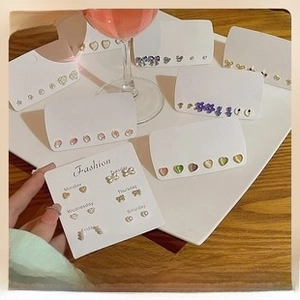 Detailed view of s925 silver needle stud earring set on display cards with week labels