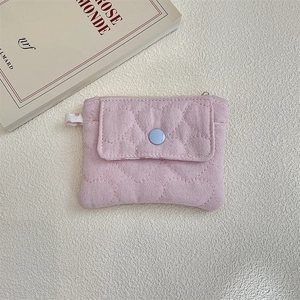Close-up of pink quilted coin purse with heart pattern, front snap pocket and zipper