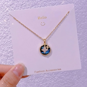 Dettaglio della collana pianeta in oro con ciondolo galassia blu e stella di cristallo