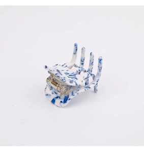 Detail of blue and white marble pattern acetic acid hair claw clip with metal spring