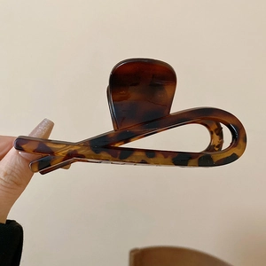 Close-up of minimalist tortoiseshell plastic hair claw clip with cross design details