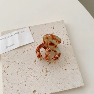 Détail d'une pince à cheveux en acétate écaille de tortue sur un support en pierre