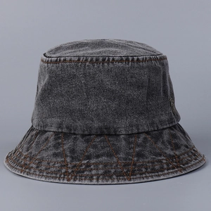 Close-up of deep gray washed denim bucket hat with decorative orange contrast stitching