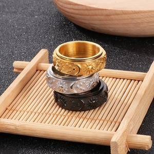 Stacked celestial spinner rings with sun and moon engravings in gold, silver and black